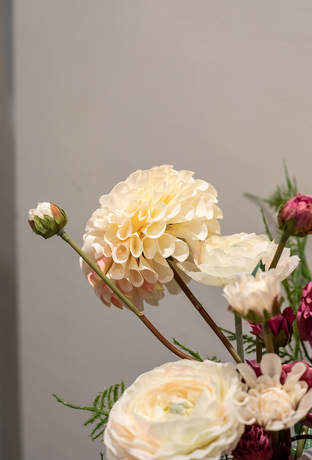 Kunstig buket Stjernestrøet Flor med orkidé i blommefarve, cremefarvet og pink dahlia, hvid ranunkel og grøn bregne – naturtro og elegant.
