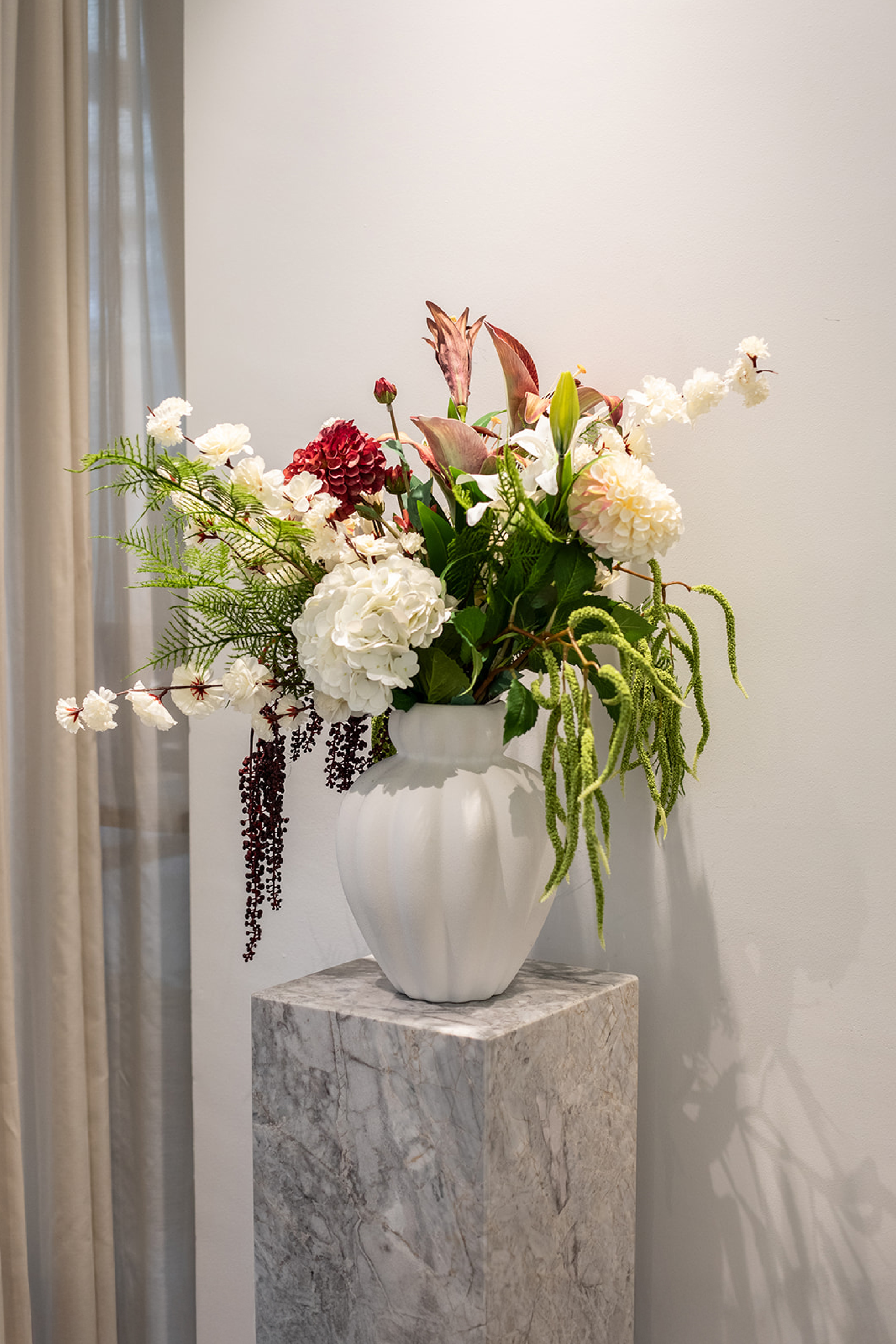 Kunstige blomster sammensat til en buket. Buketten er stylet i Penelope vase i large i farven off-white.
Buketten indeholder
1 x White Hydrangea
2 x Creme Dahlia
3 x Green Fern branch
2 x White Cherry Blossom
3 x Green hanging branch 2
1 x Sunset Dahlia
1 x Creme Peony
1 x Burgundy Berry branch
1 x Burgundy Lily branch