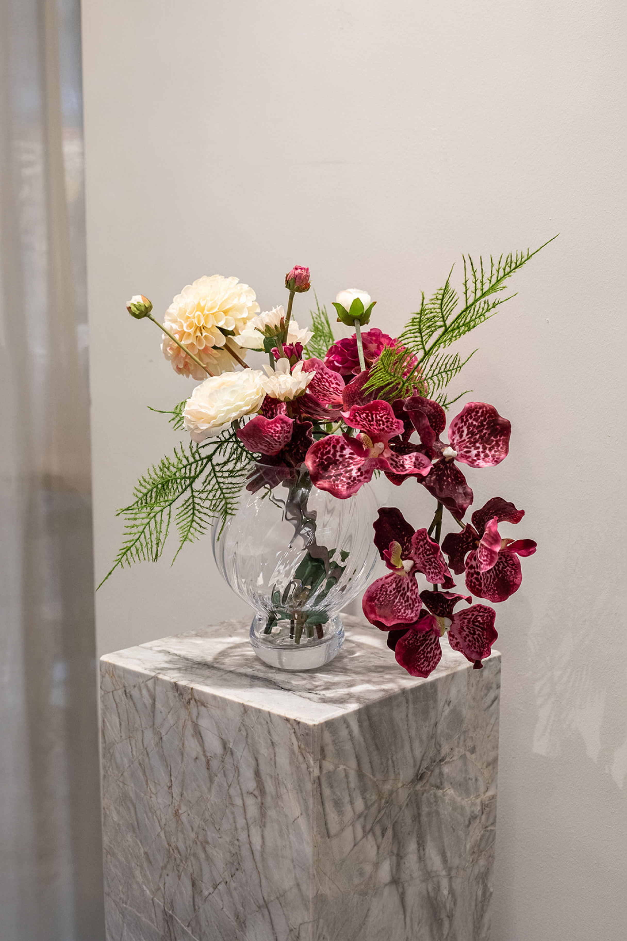 Kunstig buket Stjernestrøet Flor med orkidé i blommefarve, cremefarvet og pink dahlia, hvid ranunkel og grøn bregne – naturtro og elegant.