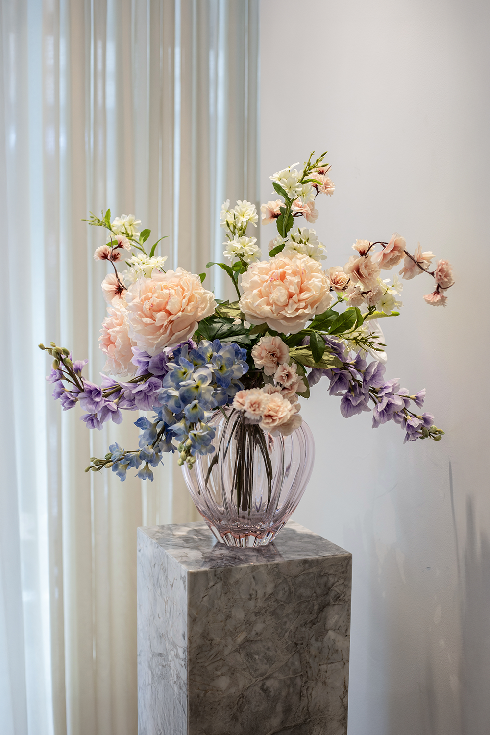 Stor kunstig men naturtro blomsterbuket i lyserøde og lilla nuancer